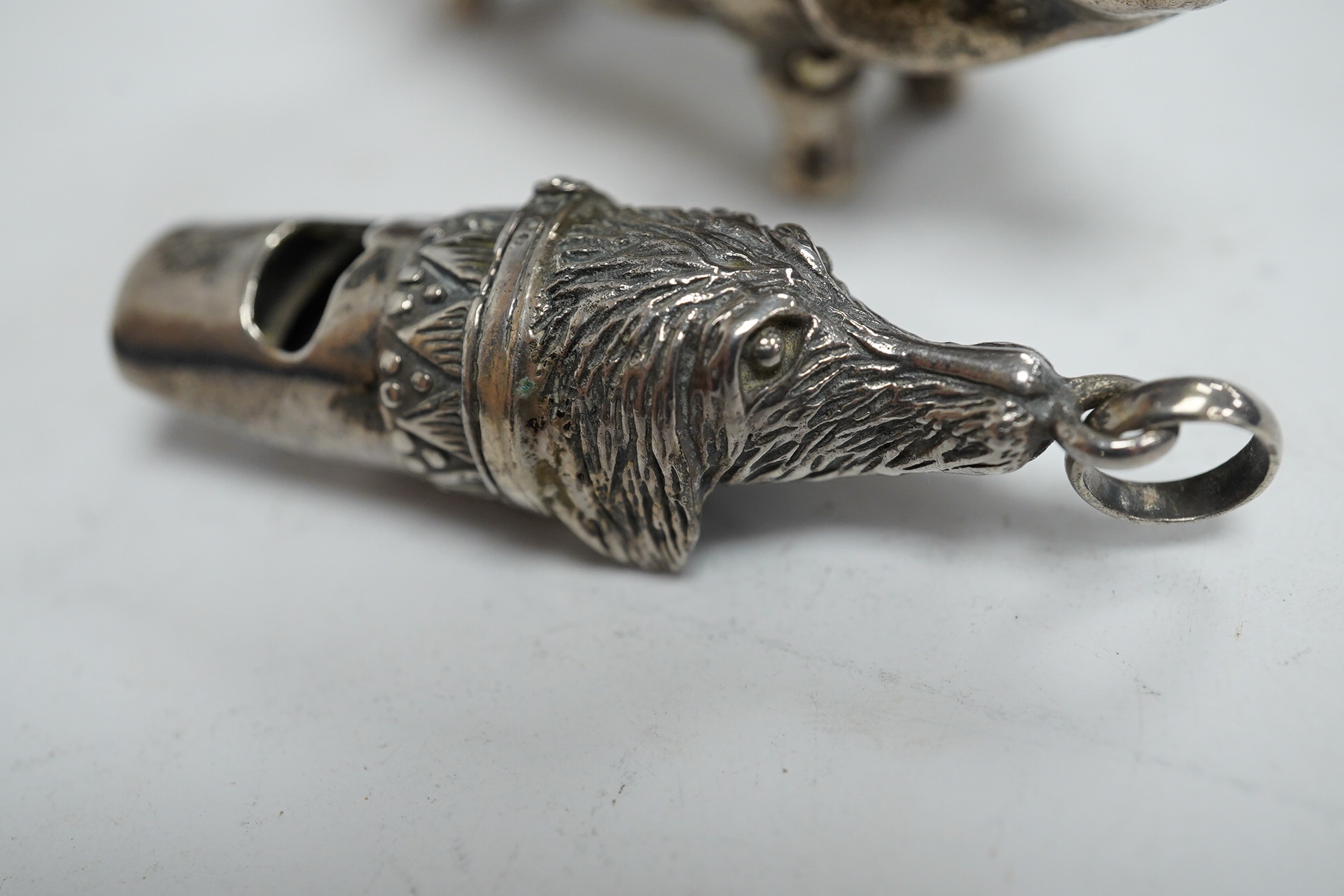 A modern silver novelty vesta case modelled as a pig, by David A. Bowles, London, 1902, 62mm, together with a novelty sterling whistle modelled as a dog's head. Condition - fair to good